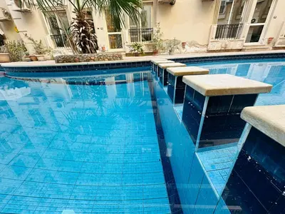 a swimming pool with blue water in a building at Cleopatra Style City Center in Hurghada