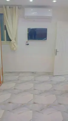 a room with a white wall and a tile floor at أهلا بكم in Luxor