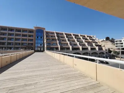 a boardwalk leading to a large apartment building at Studil for rent in the view 608 in Hurghada