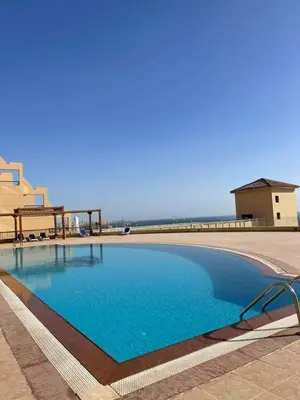 a large blue swimming pool next to a building at Studil for rent in the view 608 in Hurghada