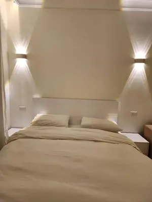 a bedroom with a large bed with two lights on it at Studio for rent in the view 607 in Hurghada