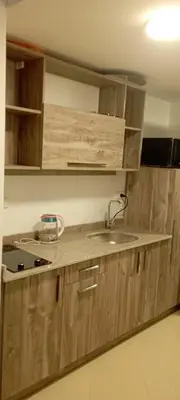 a kitchen with wooden cabinets and a sink at Florenza Resort in Hurghada