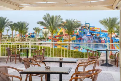 a water park with tables and chairs and a roller coaster at JAZ Aquaviva in Hurghada