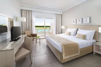 a hotel room with a large bed and a television at JAZ Aquaviva in Hurghada
