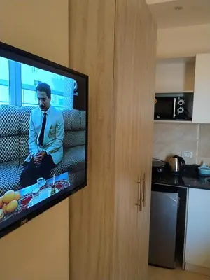 a television with a man on it in a kitchen at Casablanca Beach for families only in Hurghada