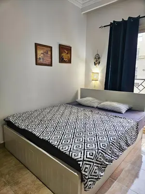 a bedroom with a bed with a black and white comforter at Sheraton Plaza 218 in Hurghada