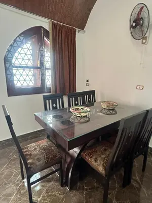 a dining room table with four chairs and a table and a window at ZAIN PALACe in Jazīrat al ‘Awwāmīyah
