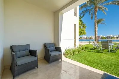 two chairs on a patio with a view of a yard at Joubal 2BR • Premium Ground Floor in Hurghada
