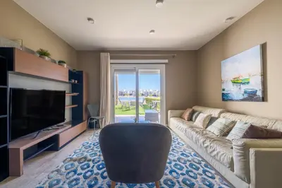 a living room with a couch and a television at Joubal 2BR • Premium Ground Floor in Hurghada