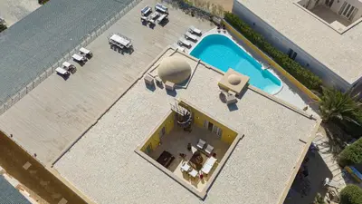 an overhead view of a pool with tables and chairs at Luxury 5BD Villa with Pool in Hurghada