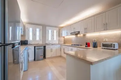 a large kitchen with white cabinets and appliances at 2BR New Marina Bliss • Cozy Centered Stay in Hurghada
