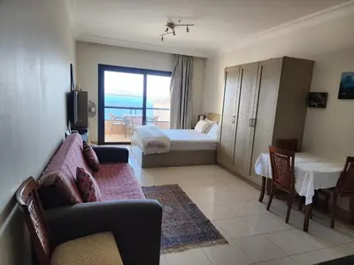 a hotel room with a bedroom with a bed and a couch at Studio for rent in the view 409 in Hurghada