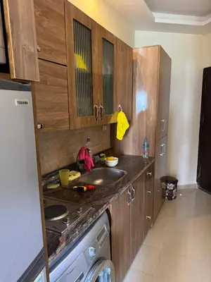 a kitchen with a sink and wooden cabinets at Studio in Casablanca 631 in Hurghada