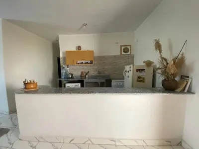 a kitchen with a white counter top in a room at Asmara Apartment Hatshepsut in Naj‘ al Madāmūd