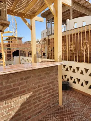 a patio with a brick wall and a wooden pergola at 2BD Apt, Douplex, 2 floors, Villa Yanny, El Helal, Hurghada in Hurghada
