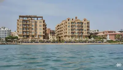 a view of the beach and buildings from the water at Turtles Beach Resort Al Ahyaa in Hurghada