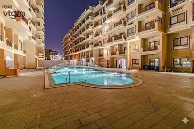 a large apartment building with a large swimming pool at Turtles Beach Resort Al Ahyaa in Hurghada