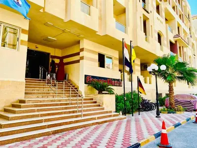 a building with stairs in front of a building with flags at Florenze Khamsin Hurghada in Hurghada