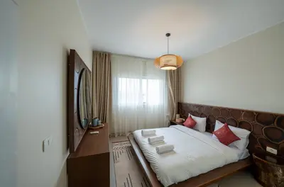 a bedroom with a large bed and a mirror at Joubal 2BR • Top Floor Lagoon View in Hurghada