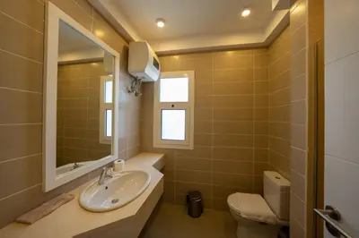 a bathroom with a sink and a toilet at Joubal 2BR • Top Floor Lagoon View in Hurghada