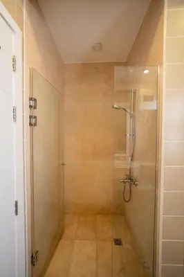 a bathroom with a shower with a glass door at Joubal 2BR • Top Floor Lagoon View in Hurghada
