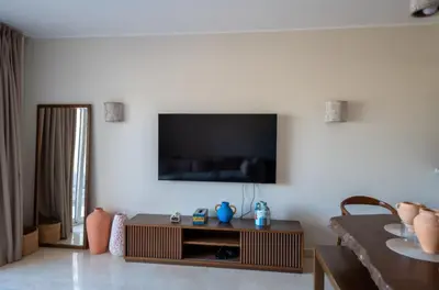 a living room with a tv on a white wall at Joubal 2BR • Top Floor Lagoon View in Hurghada