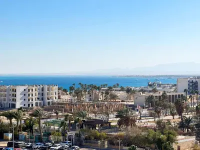 a city with palm trees and buildings and the ocean at Sea View Aldau Hights in Hurghada