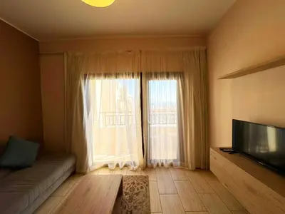 a living room with a couch and a large window at Sea View Aldau Hights in Hurghada