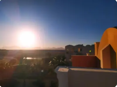 a view of the sunset from the balcony of a building at One bedroom flat with large terrace in a villa with swimming pool in Hurghada