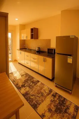 a kitchen with a stainless steel refrigerator and cabinets at Golden tiba resort in Hurghada