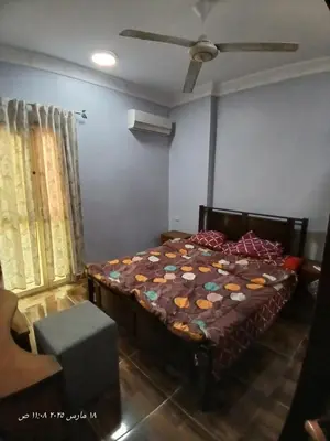a bedroom with a bed and a ceiling fan at Hotel apartments in Hurghada