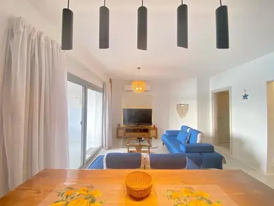 a living room with a blue couch and a table at Hotel apartment swan lake in Hurghada
