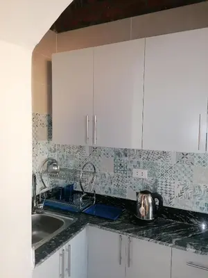 a kitchen with white cabinets and a sink at الكوثر القديم الغردقة in Hurghada