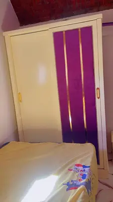 a bed in a room with a purple door at habby home in Aswan
