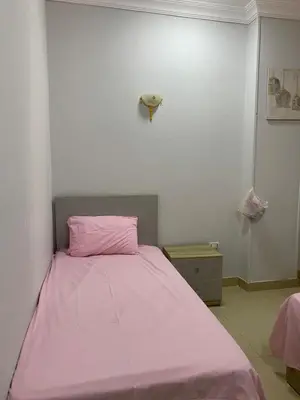 a pink bed in a white room with a pink blanket at Apartment in centre of Hurghada in Hurghada