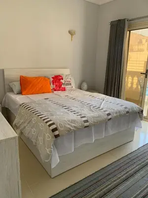 a bedroom with a large bed with an orange pillow at Apartment in centre of Hurghada in Hurghada