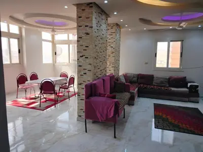 a living room with a couch and a table and chairs at اسوان ـ خلف مول بلازا ـ بجوار فرست مول in Aswān
