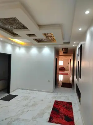 a hallway with white walls and a red rug at اسوان ـ خلف مول بلازا ـ بجوار فرست مول in Aswān