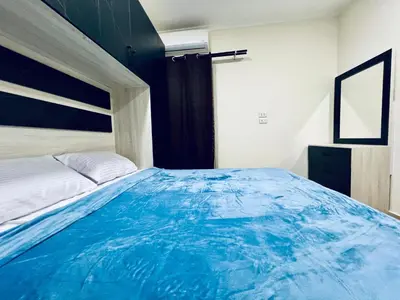 a bedroom with a large bed with blue sheets at Beachfront Bliss - Your Hurghada Escape Awaits in Hurghada