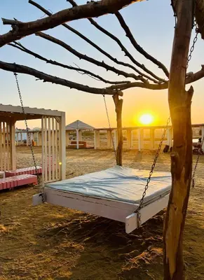 a bed in a tree with the sunset in the background at Beachfront Bliss - Your Hurghada Escape Awaits in Hurghada
