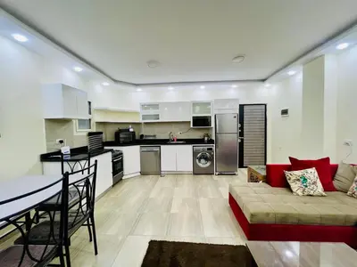 a kitchen and living room with a couch and a table at Beachfront Bliss - Your Hurghada Escape Awaits in Hurghada