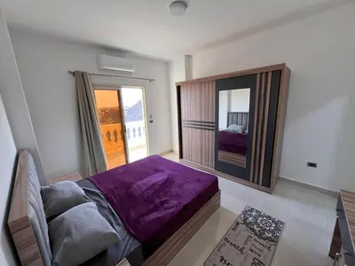 a bedroom with a purple bed and a mirror at Apartment with a Red Sea view in Hurghada