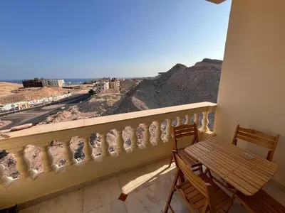 a balcony with a bench and a view of the desert at Apartment with a Red Sea view in Hurghada