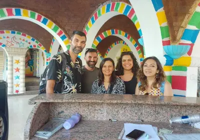 a group of people standing in front of a counter with a rainbow at Zena Toma Nubian Guest House in Aswan