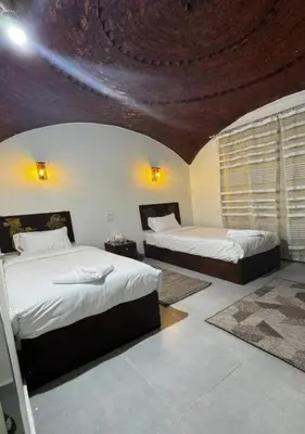 a bedroom with two beds and a ceiling at Zena Toma Nubian Guest House in Aswan