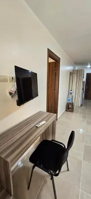 a black chair sitting in front of a desk with a television at Tiba Golden Marina Bay Hurghada in Hurghada