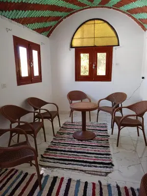 a room with tables and chairs and a window at Toto Kato in Jazīrat Aswān