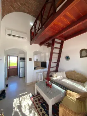a living room with a staircase and a couch and a table at Apartment at Upper Nubia lagoon El Gouna in Hurghada