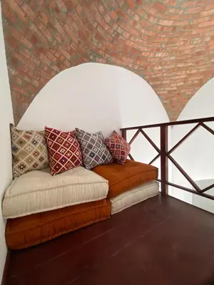 a couch sitting in a room with a brick wall at Apartment at Upper Nubia lagoon El Gouna in Hurghada