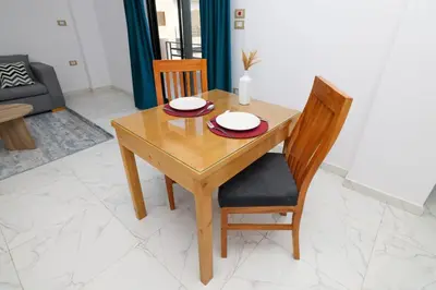 a wooden table with two plates on it in a living room at Serenity House Luxor in Luxor